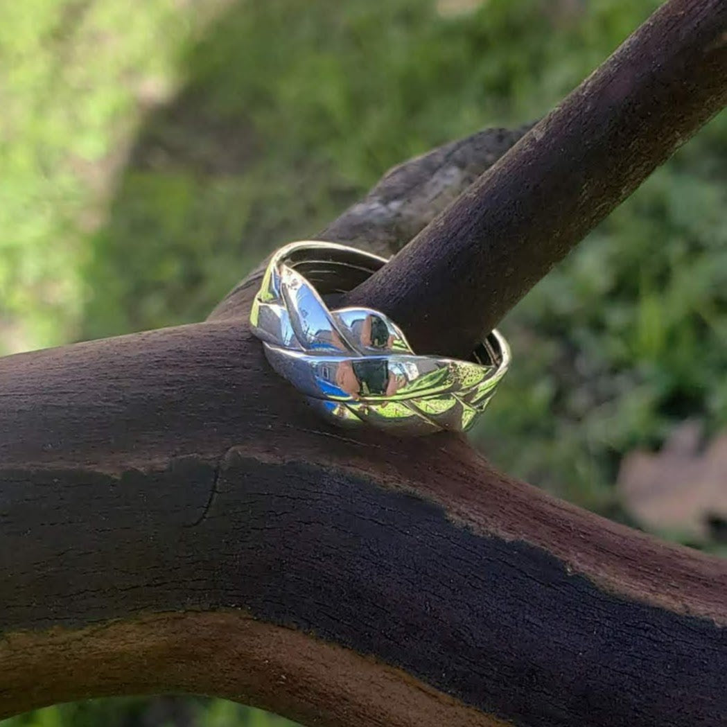 High shine sterling silver puzzle ring on madrone tree branch, assembled